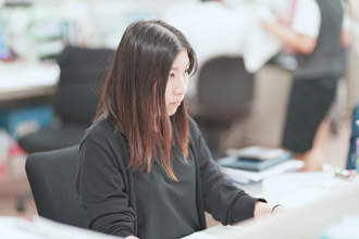 若い女性がパソコンで事務作業を行っている写真